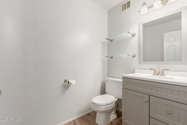 a bathroom with a toilet a sink a mirror and vanity