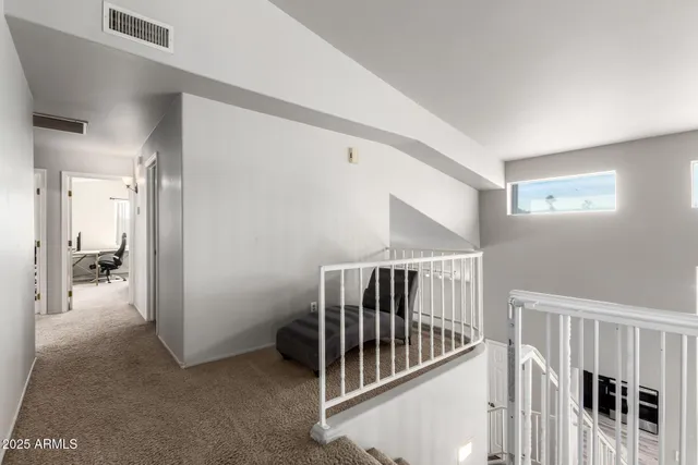 a view of staircase with white walls and racks