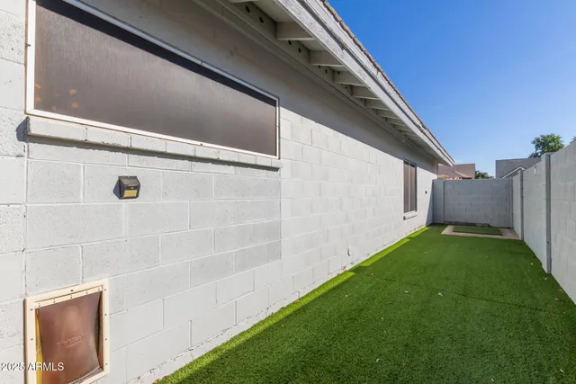 a view of backyard with barbeque grill and wooden fence