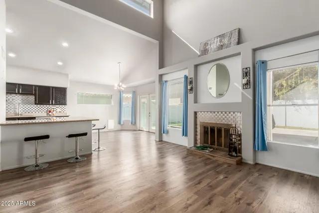 a large white kitchen with granite countertop a stove top oven a fireplace with wooden floor