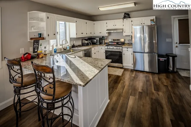 a kitchen with granite countertop a stove sink and cabinets
