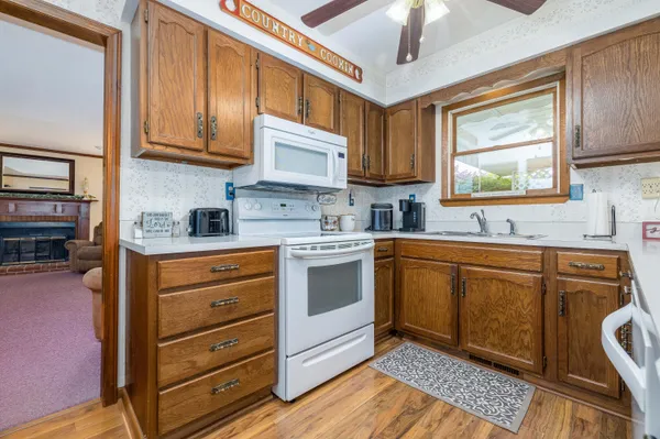 a kitchen with stainless steel appliances granite countertop a sink dishwasher stove and cabinets with wooden floor