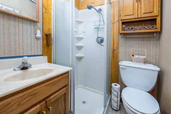 a bathroom with a sink a toilet and shower
