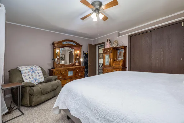 a bedroom with a bed and dresser with mirror