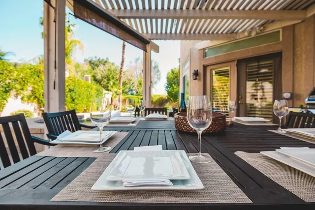 a view of an outdoor dining space with furniture and outside view