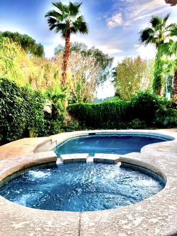a front view of a house with a yard and potted plants