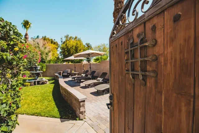 a view of a swimming pool with a table and chairs under an umbrella