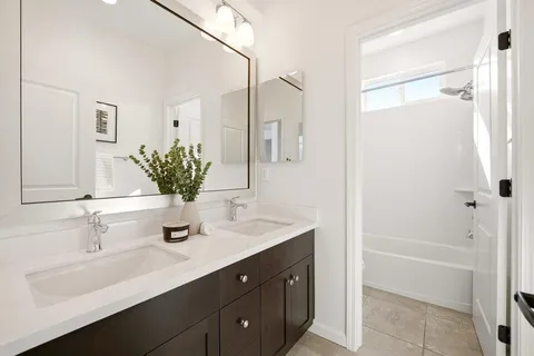 a bathroom with a shower sink vanity and mirror