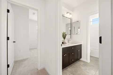 a spacious bathroom with a double vanity sink a large mirror and a shower