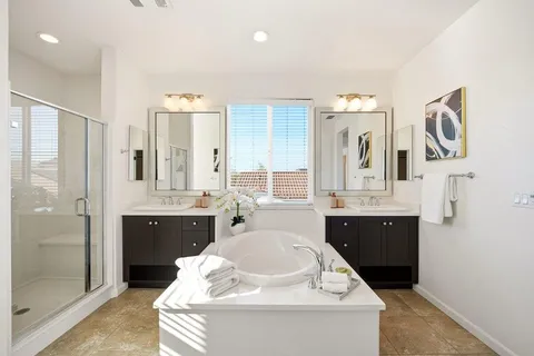 a spacious bathroom with a bathtub sink and mirror