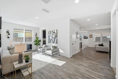 a living room with furniture and a wooden floor