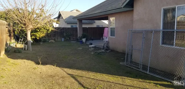 a view of backyard with wheel chair potted plants and wooden fence
