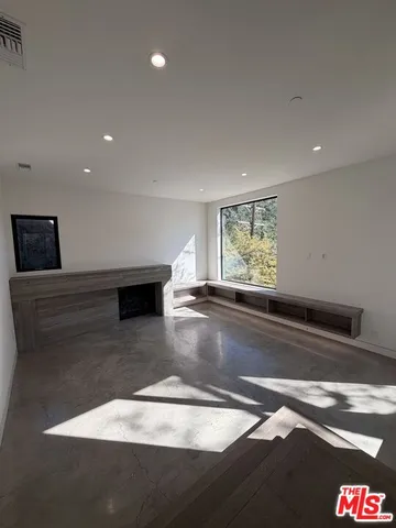 a view of empty room with window and fireplace