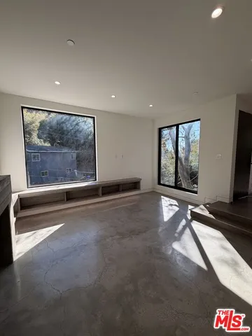 a view of an empty room with windows and wardrobe