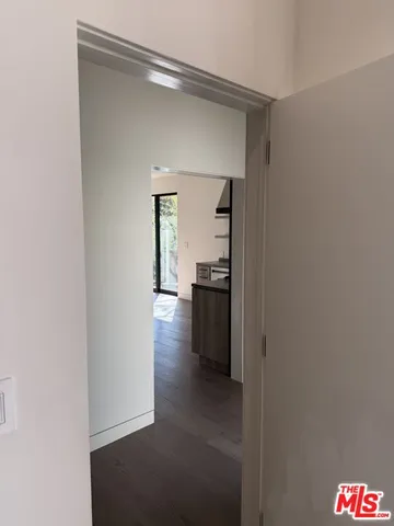 a view of a hallway with wooden floor and a living room