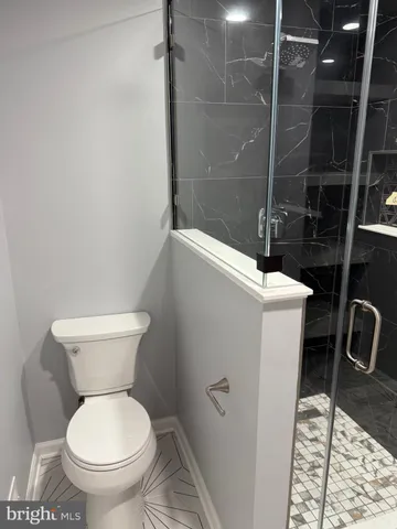 a bathroom with a toilet and a shower