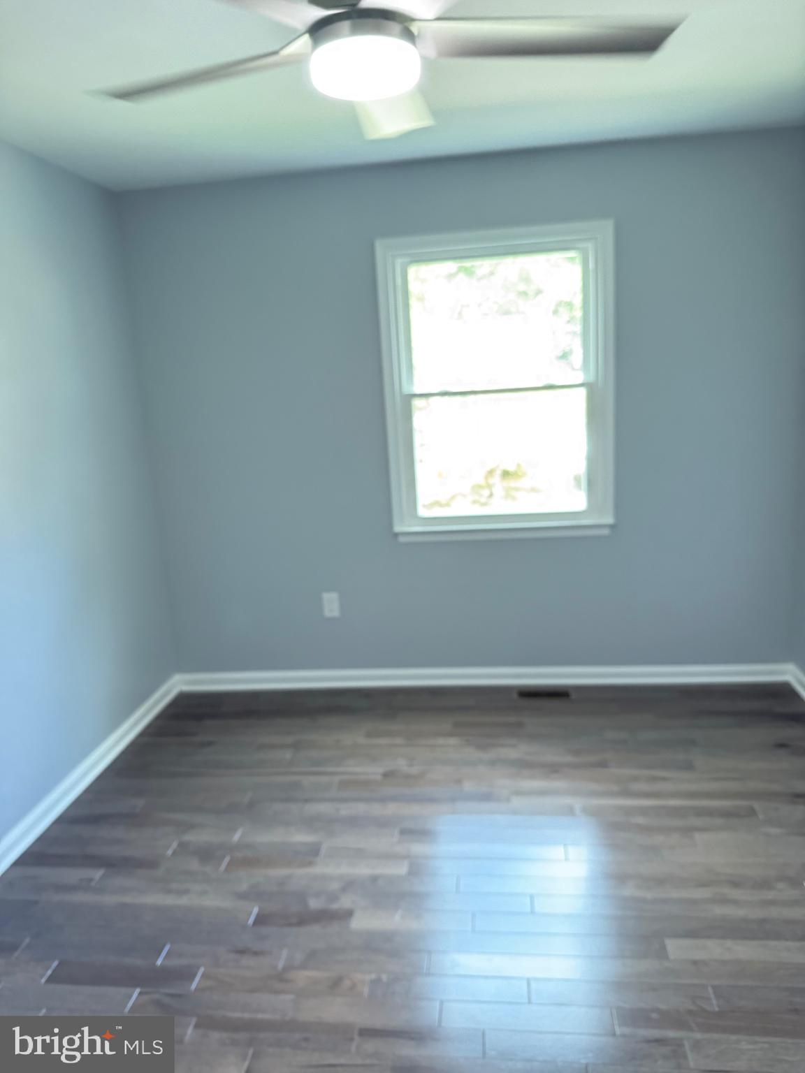 7810 Newington Woods Drive Springfield, VA 22153 - Photo 22 of 50 an empty room with wooden floor and windows