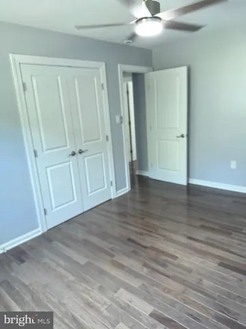 an empty room with wooden floor and cabinet