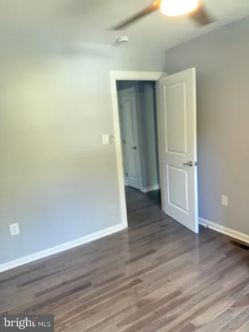 an empty room with wooden floor and closet
