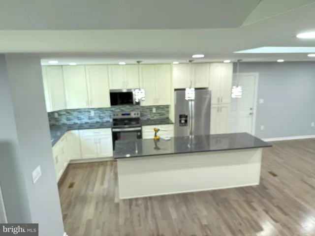 a large kitchen with stainless steel appliances granite countertop a stove a sink and a granite counter tops
