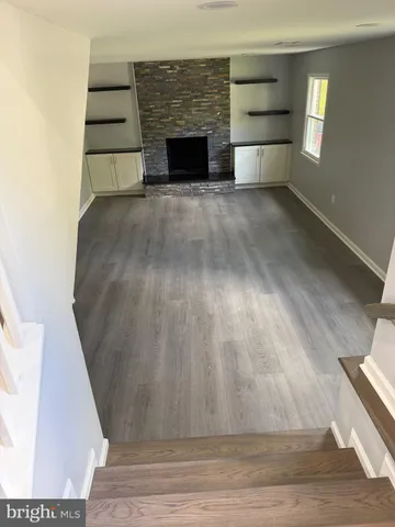 a view of empty room with a fireplace and window