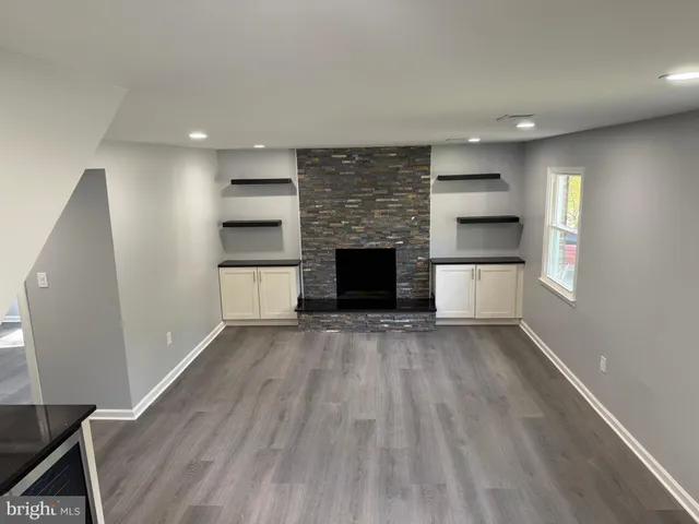 an empty room with kitchen and fireplace