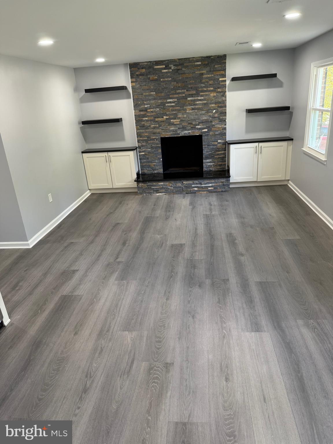 7810 Newington Woods Drive Springfield, VA 22153 - Photo 42 of 50 a view of kitchen and empty room with wooden floor fireplace