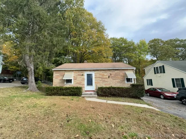 a front view of a house with a yard and trees