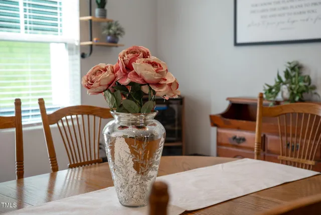 a view of a dining room and livingroom with furniture wooden floor a chandelier