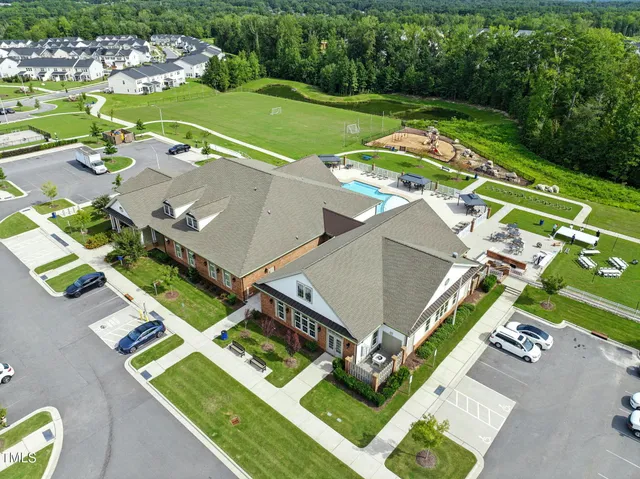 an aerial view of a house with swimming pool and a yard