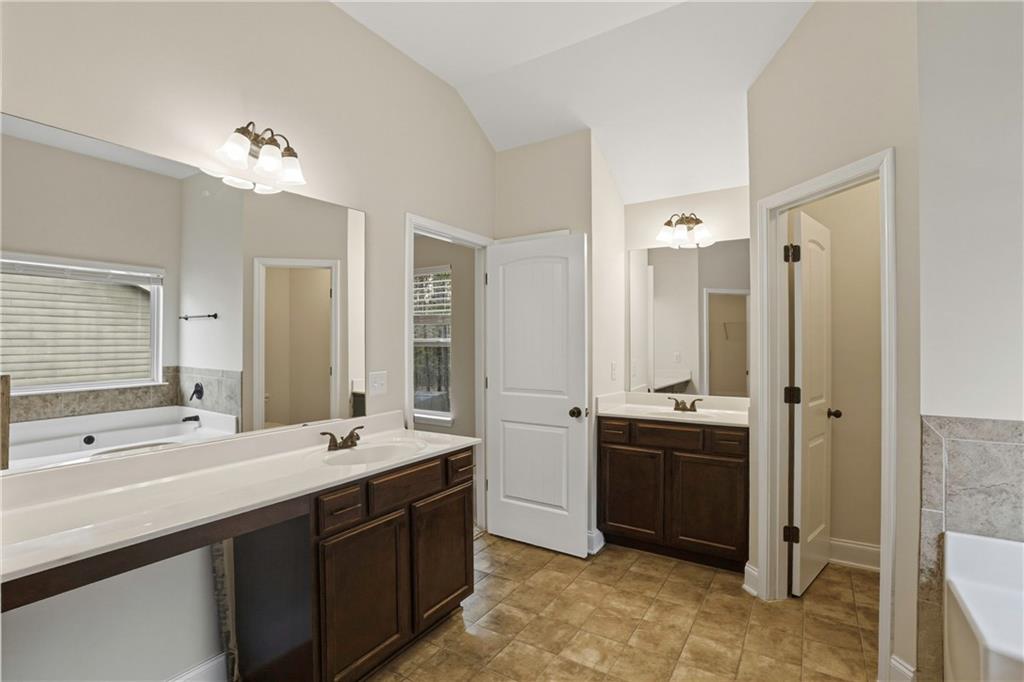 1423 Stone Ridge Court Hampton, GA 30228 - Photo 20 of 22 a spacious bathroom with double vanity and a mirror