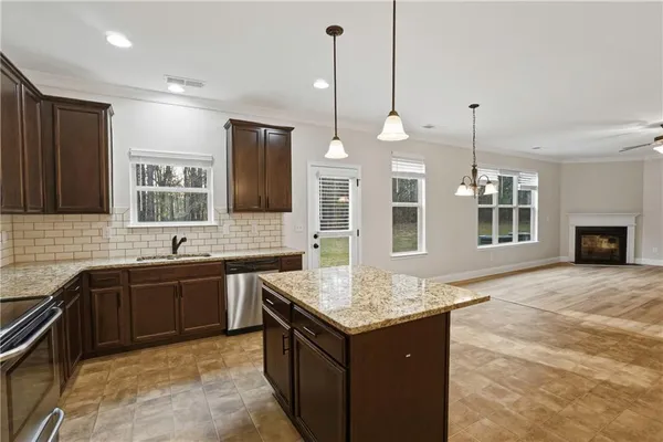 a kitchen with granite countertop sink stove and refrigerator
