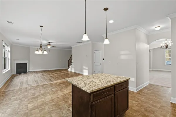 a kitchen that has a kitchen island a stove and a chandelier