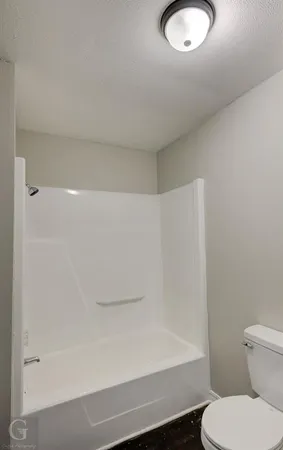 a bathroom with a toilet and a tub