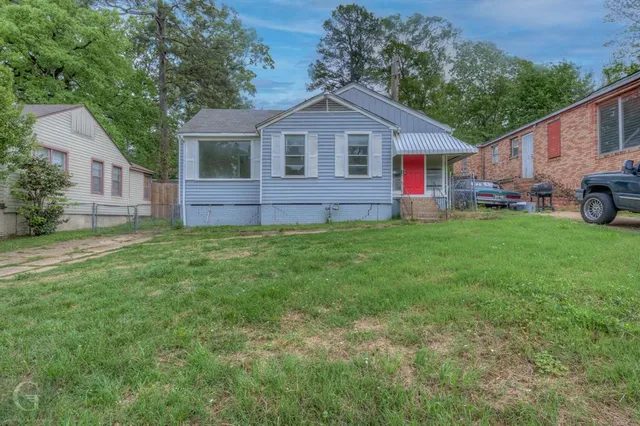 a front view of a house with a garden and trees