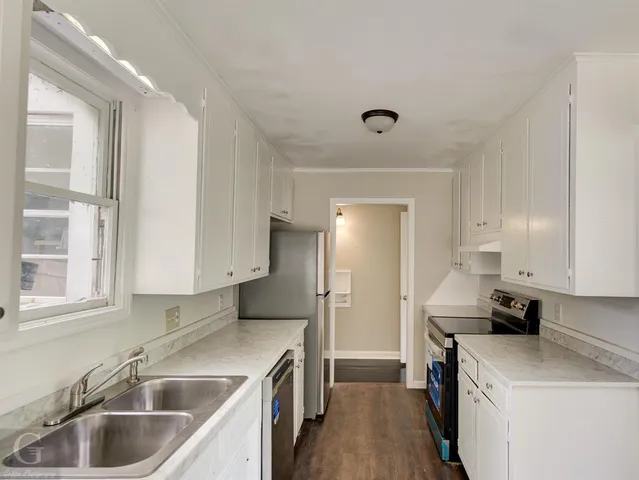 a kitchen that has a sink and a refrigerator