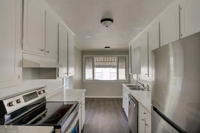 a kitchen with granite countertop a stove and a refrigerator