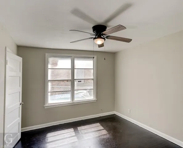 an empty room with a window and a ceiling fan