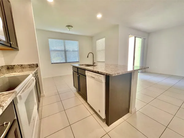 a kitchen with a sink a stove top oven and cabinetry