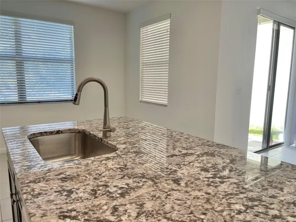 a kitchen with granite countertop a sink and a stove