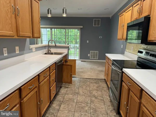 a kitchen with a sink stove top oven and cabinets