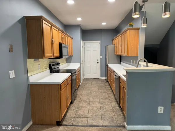 a kitchen with kitchen island granite countertop a sink a counter top space and cabinets