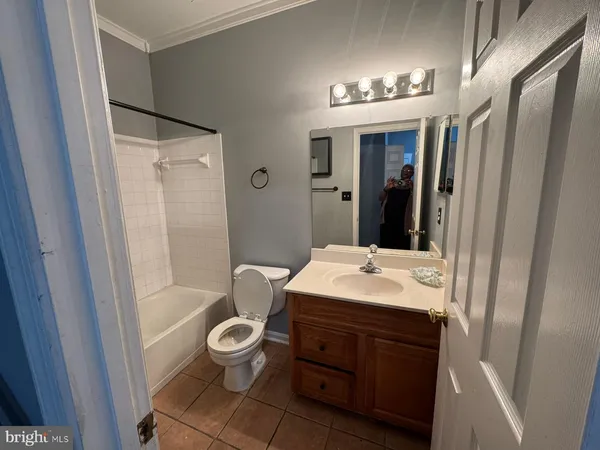 a bathroom with a sink a toilet a mirror a bathtub and shower