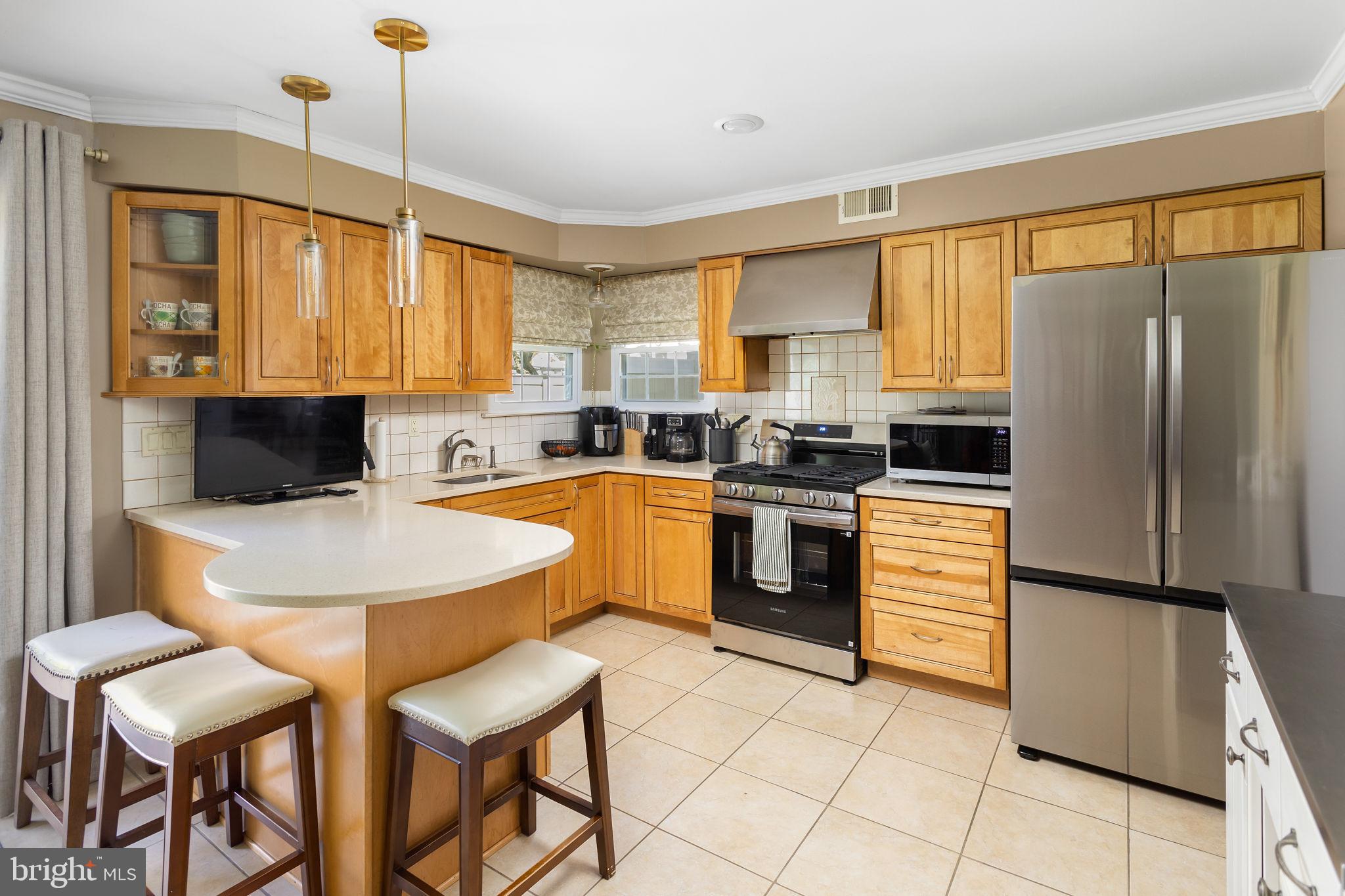 18 Geraldine Road East Windsor, NJ 08520 - Photo 15 of 42 a kitchen with a refrigerator a stove top oven dining table and chairs