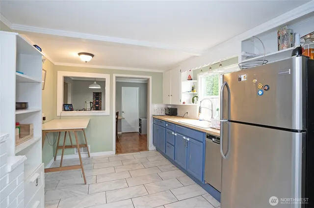 a kitchen with a refrigerator a sink and chairs