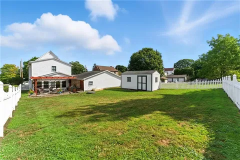 a view of a house with a yard and sitting area