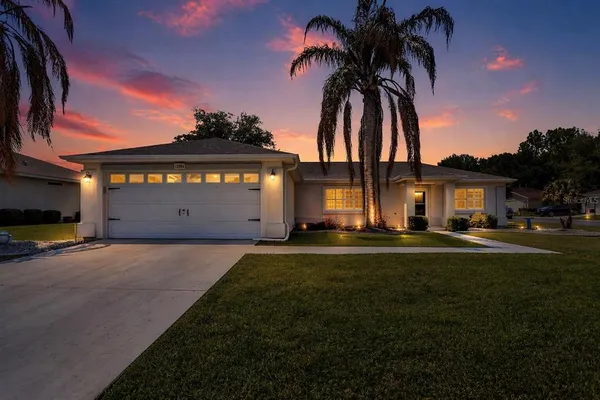 a front view of a house with a garden and garage