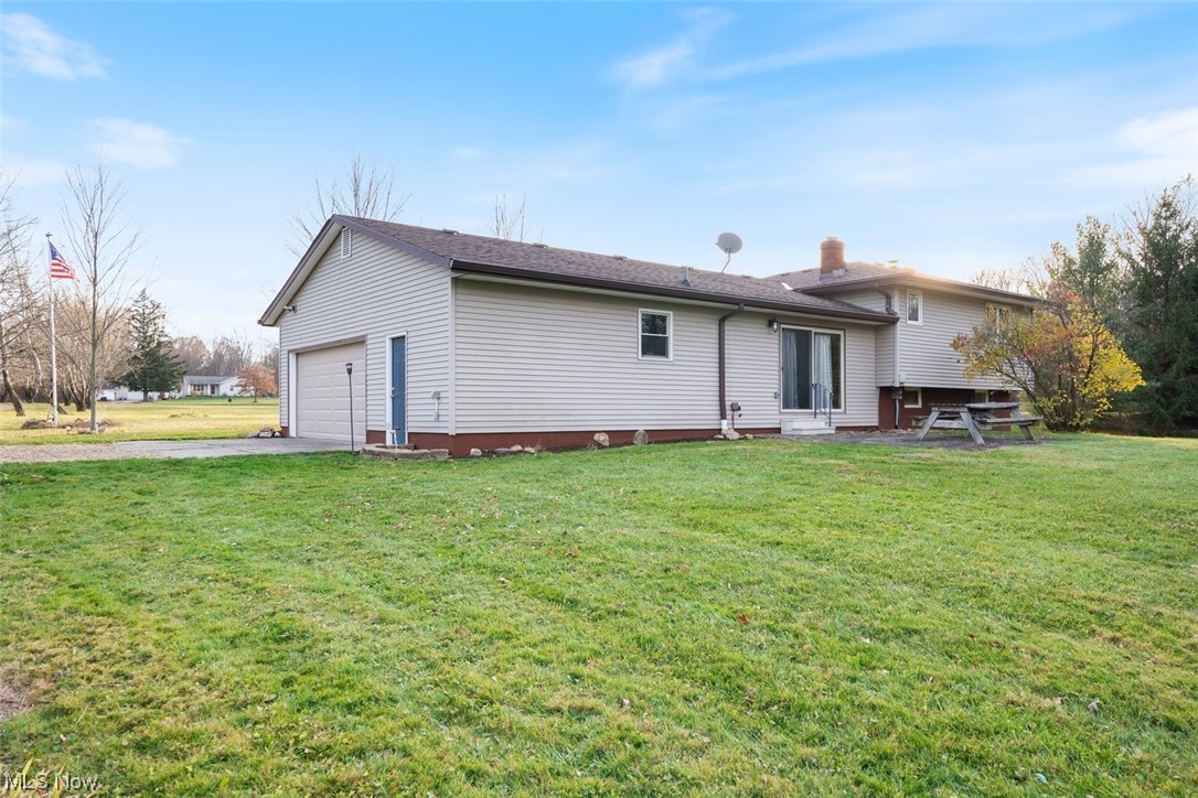 8221 Stone Road Medina, OH 44256 - Photo 29 of 35 Back of property with a garage and a lawn