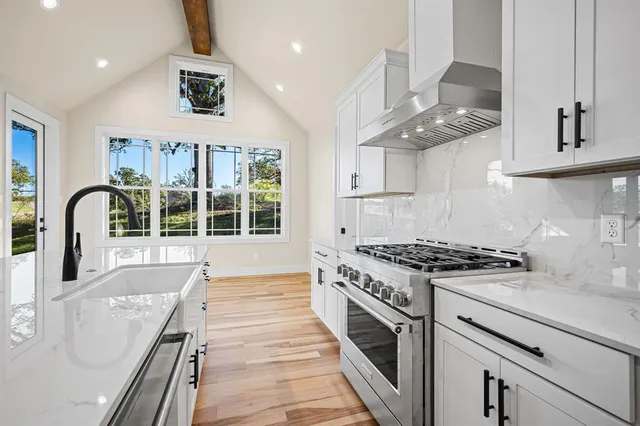 a kitchen with stainless steel appliances granite countertop a stove and a sink