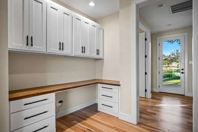 a view of kitchen with wooden floor and cabinets